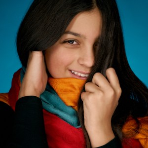 blízky portrét dievčaťa s farebnými šálmi a ofinou cez jedno oko