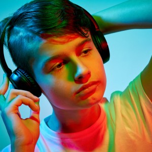farebný portrét chlapca so slúchadlami na ušiach, svietené farebnými gélmi